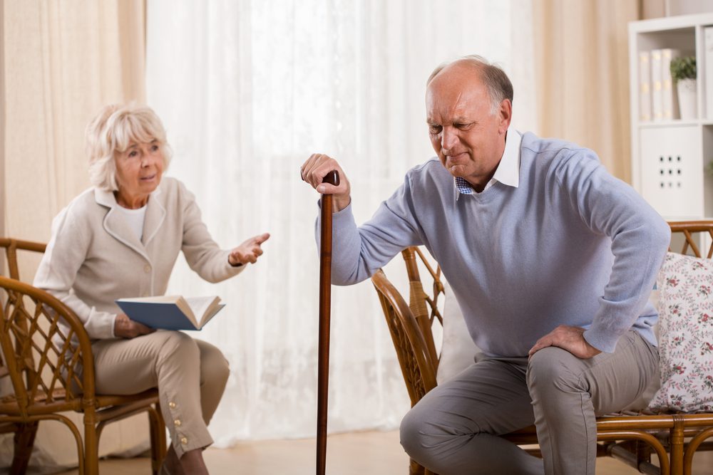 living with osteoarthritis Person with osteoarthritis strugling to get up using a cane