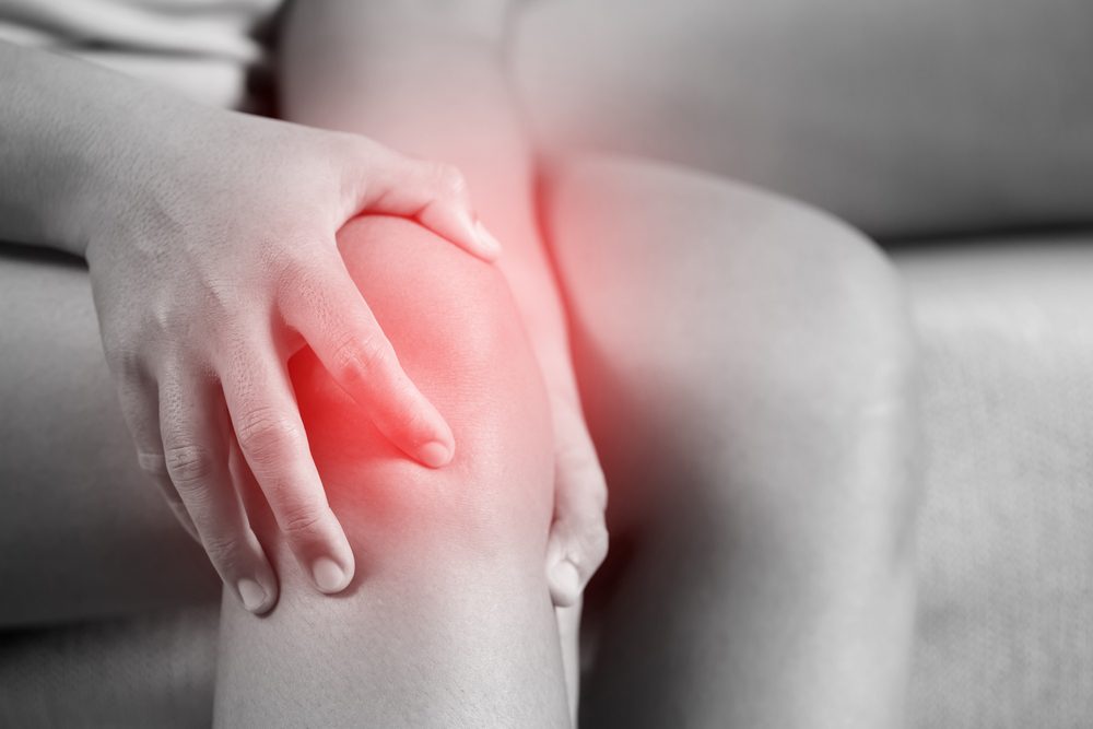 Arthritis knee pain Person with arthritis holding their knee in pain