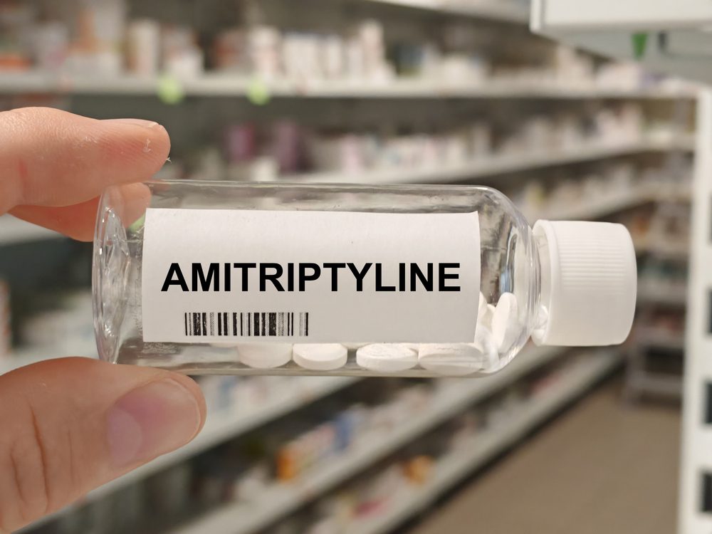 Amitriptyline pills A bottle of Amitriptyline pills being held by someone in a pharmacy.