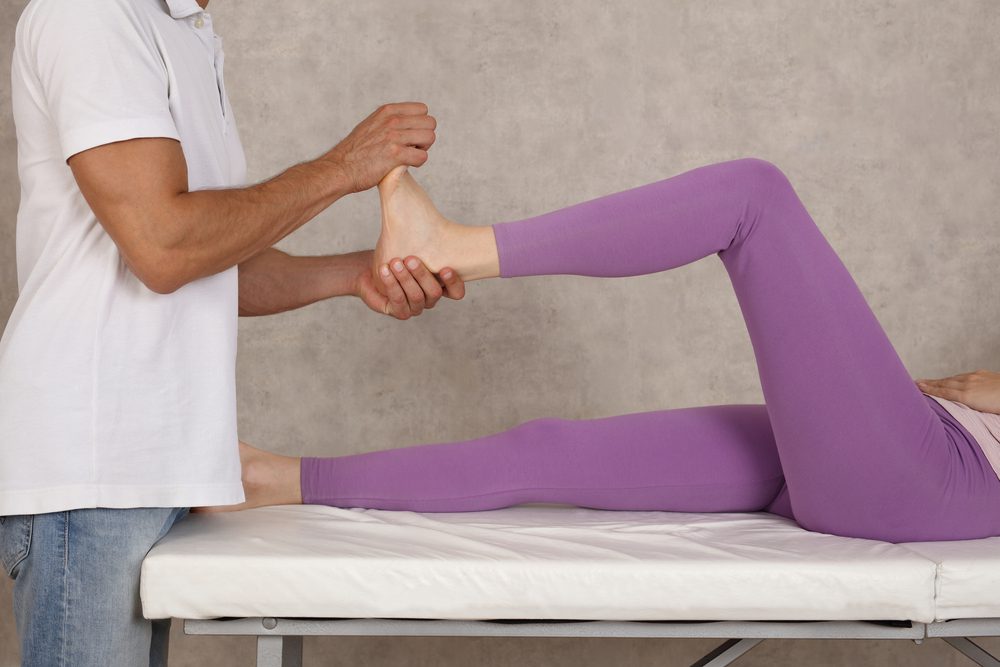 Physiotherapist helping treat insertional Achilles tendinopathy. Physiotherapist helping treat insertional Achilles tendinopathy.