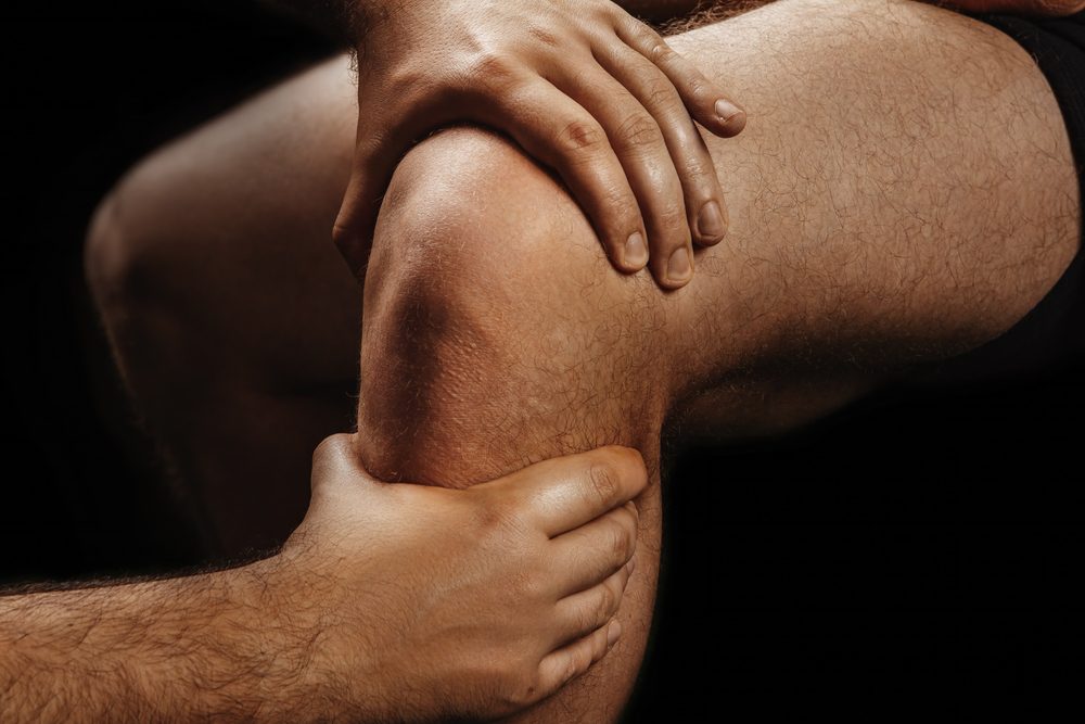 Knee pain. Person suffering from knee pain.