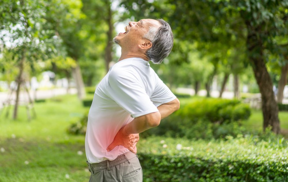 Spinal arthritis pain. Elderly man in pain due to spinal arthritis.