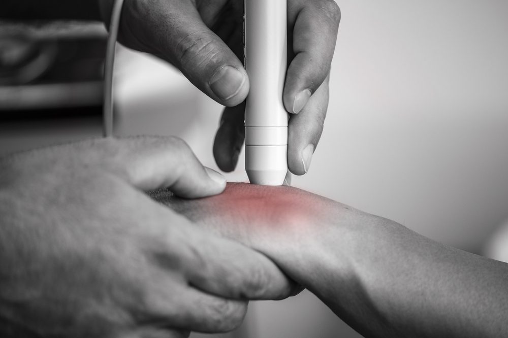 wrist pain physical therapy. Physical therapist helping patient deal with wrist pain.